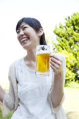 庭でビールを飲む女性