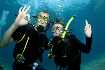 Scuba divers make OK sign underwater