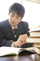 図書室で勉強する男子中学生