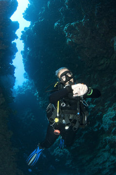 Scuba diver swims in underwater cave