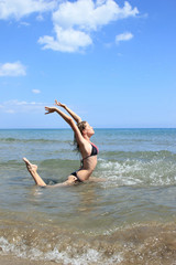 Beautiful woman jumps out of the sea