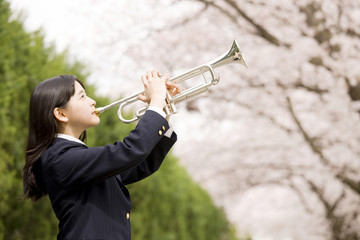 桜の下でトランペットを吹く女子中学生 © paylessimages