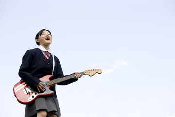 ギターを弾く女性中学生