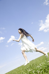 Fototapeta na wymiar 草原を走る女性