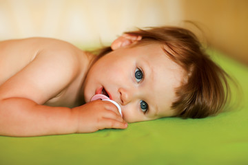 Cute baby girl with a soother in her mouth