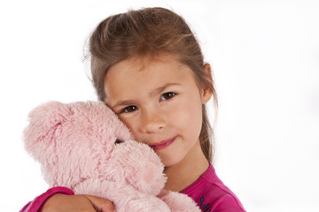Young girl with pink dress hug teddy in studio