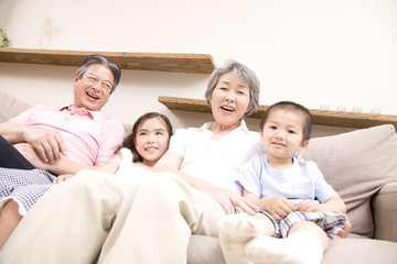 孫とソファに座る老夫婦
