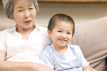 孫とソファに座る祖母