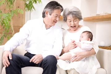 孫娘をあやす祖父と祖母