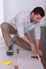 Man laying a wooden floor