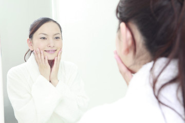 洗面台で自分の肌を気にする女性