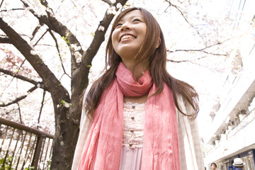 桜の下を歩く女性
