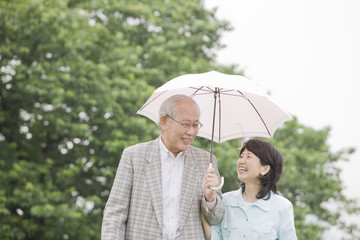 日傘をさして散歩をする老夫婦