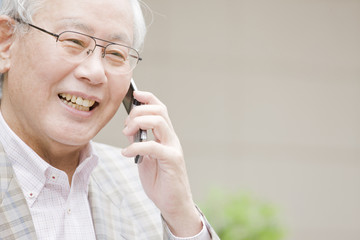 携帯電話で通話する老人
