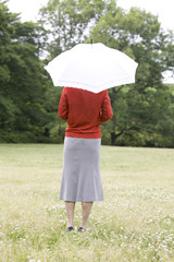 日傘を差しながら景色を眺める女性の後ろ姿