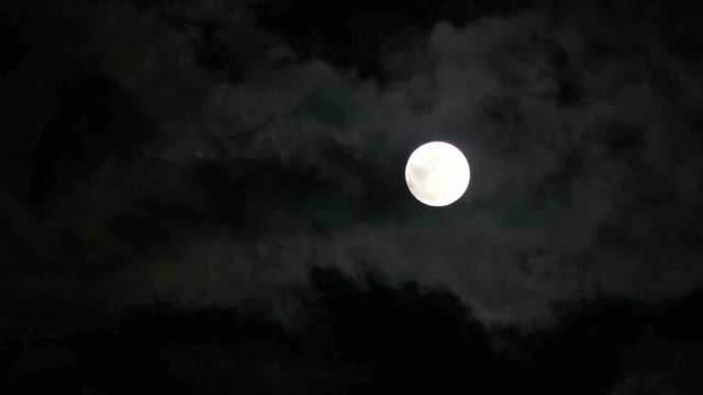雲に見え隠れする月