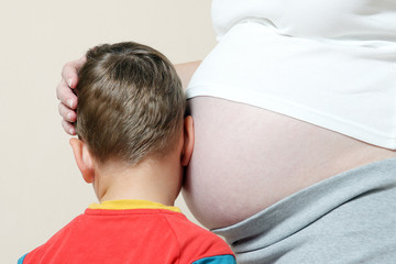 Pregnant women with son listenings sounds in gravid tummy