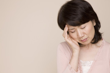 頭を押さえて俯いている女性