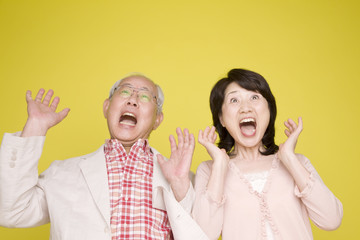 両手をあげて驚く老夫婦