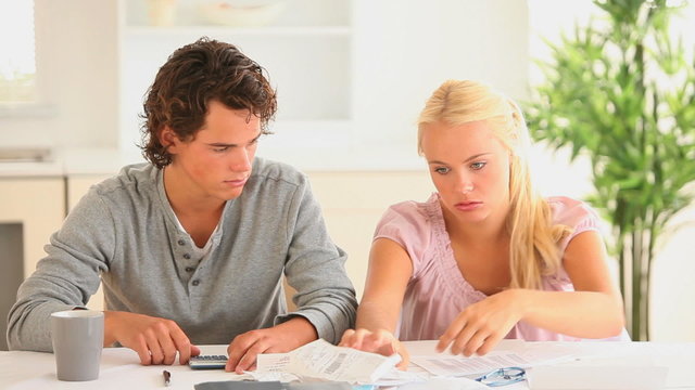 Worried couple checking at their expenses