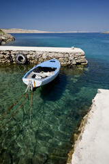Small wooden boat on the crystal sea water
