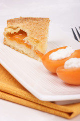 Slice of apricot tart served on a white plate