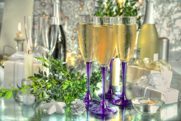 Champagne in glasses, green twig and blured lights