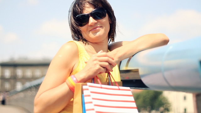 Attractive happy woman with shopping bags smiling to camera