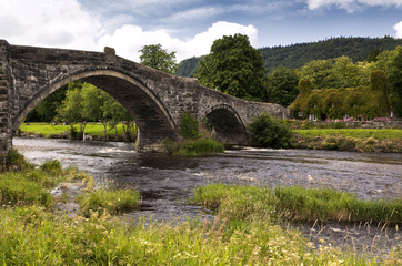 Fototapeta na wymiar Steinbrücke und altes Cottage in Llanwrst, Wales