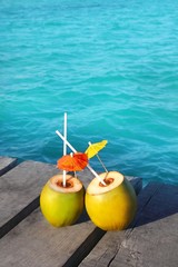 coconut coktails in caribbean on wood pier