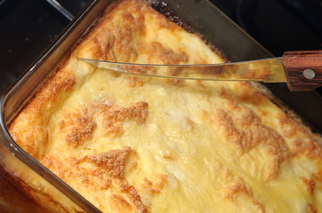 Slicing knife, freshly prepared cheesecake closeup