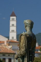 Fototapeta premium Fisherman`s statue and the church tower in Crikvenica