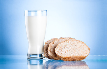 Glass of fresh milk and Three Bread Slices on blue background