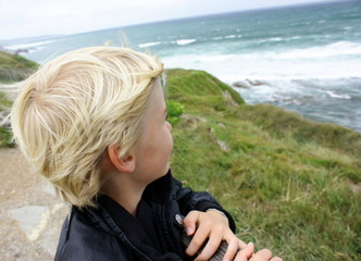 enfant cheveux au vent regardant la mer