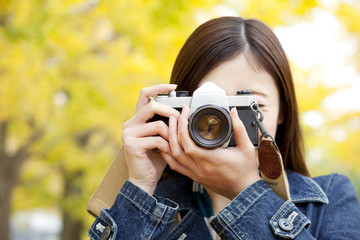 銀杏をカメラで撮る女性