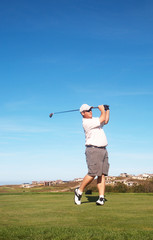 Fototapeta premium Young male golfer playing off the tee box