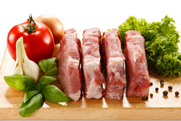 Raw pork on cutting board and vegetables