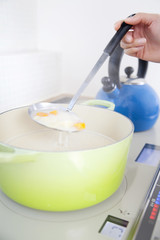 シチューをかき混ぜる女性の手元