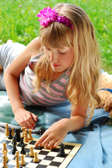 young girl playing chess outside