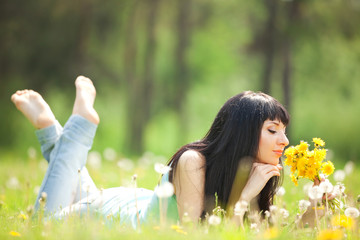 Naklejka na ściany i meble Cute woman in the park with dandelions