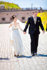 Naklejka premium Young just married couple walking holding hands