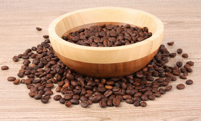 Fototapeta na wymiar Plate with coffee beans on wooden table