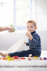 Cute kid packing toys to plastic bag