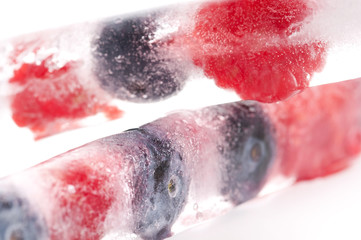 Raspberry and blackberry frozen in ice sticks