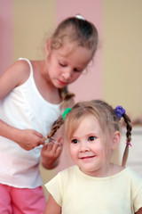Small girl getting hair comb.