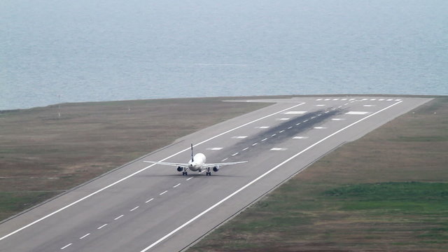Plane takes off. Airport close to the sea.