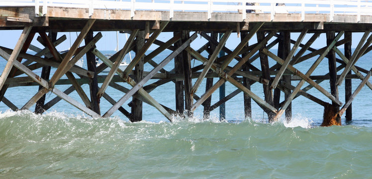 crashing waves on beach pier