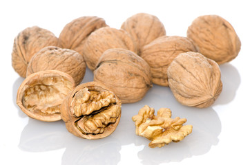 Walnuts a shell on a white reflective background.