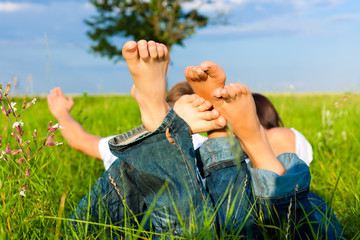 Happy couple lying on a meadow
