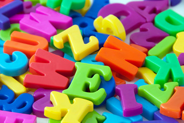 Background image of magnetic alphabet letters.